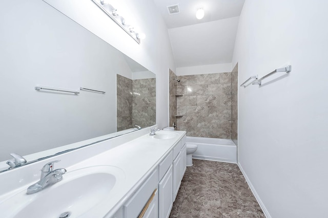 full bathroom featuring vanity, tiled shower / bath combo, and toilet