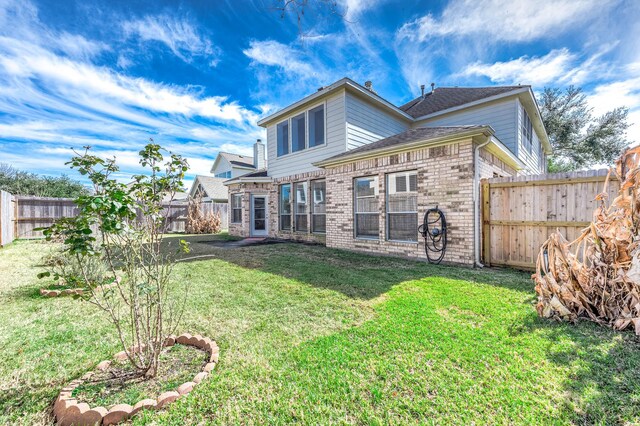 rear view of property with a yard