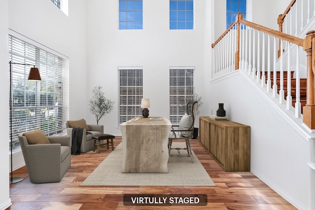 office space featuring light hardwood / wood-style floors and a high ceiling