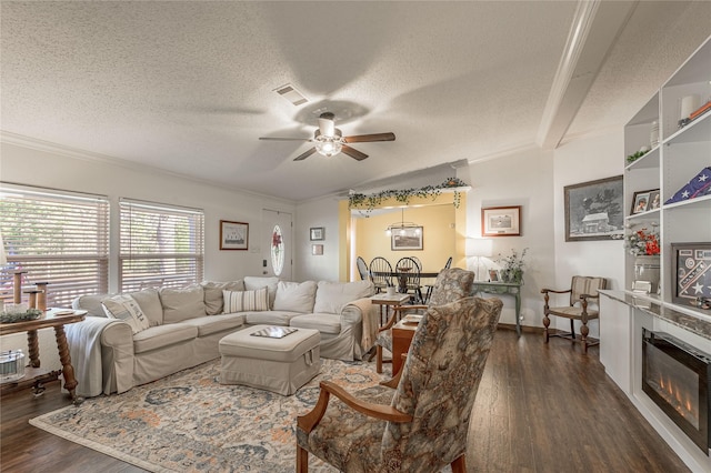 living room featuring ceiling fan, ornamental molding, dark hardwood / wood-style floors, and a textured ceiling