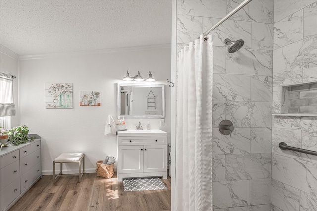 bathroom with a shower with curtain, a textured ceiling, ornamental molding, vanity, and hardwood / wood-style floors