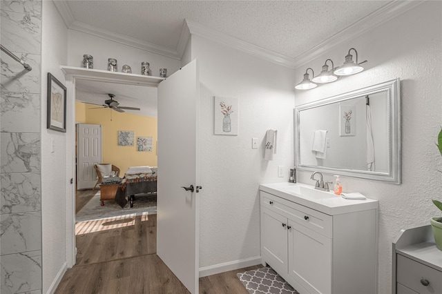 bathroom with vanity, hardwood / wood-style flooring, crown molding, and a textured ceiling