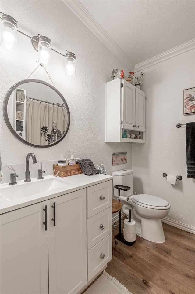 bathroom featuring hardwood / wood-style flooring, vanity, ornamental molding, toilet, and a textured ceiling