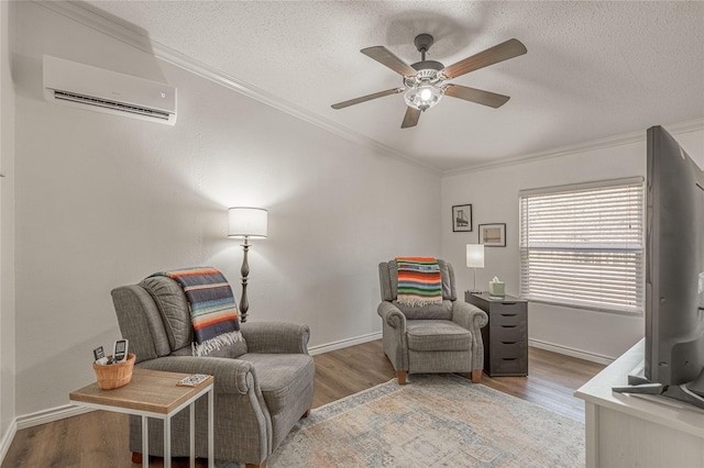 sitting room featuring crown molding, wood-type flooring, a wall mounted AC, and a textured ceiling