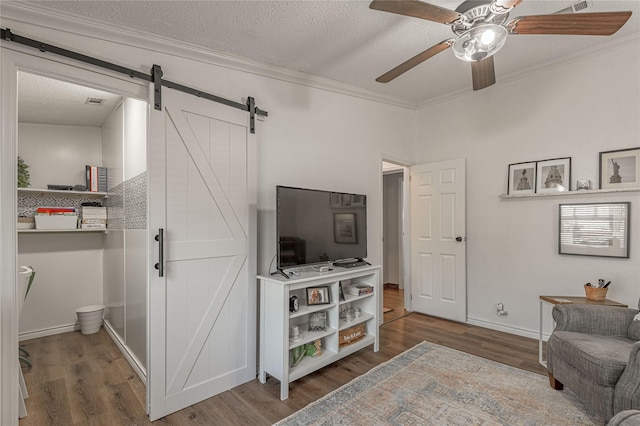 living room featuring a barn door, hardwood / wood-style floors, and a textured ceiling