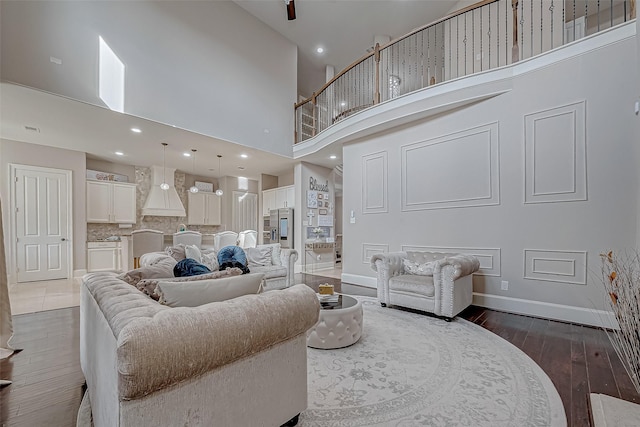 living room with dark wood-type flooring and a high ceiling