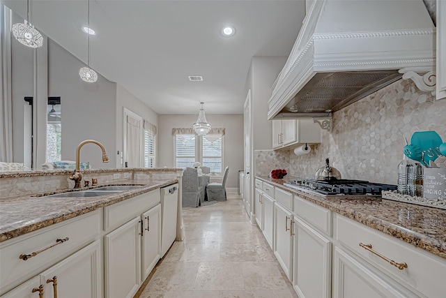 kitchen featuring stainless steel appliances, premium range hood, sink, and pendant lighting