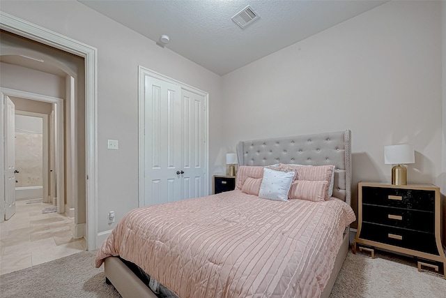 carpeted bedroom featuring a closet and a textured ceiling