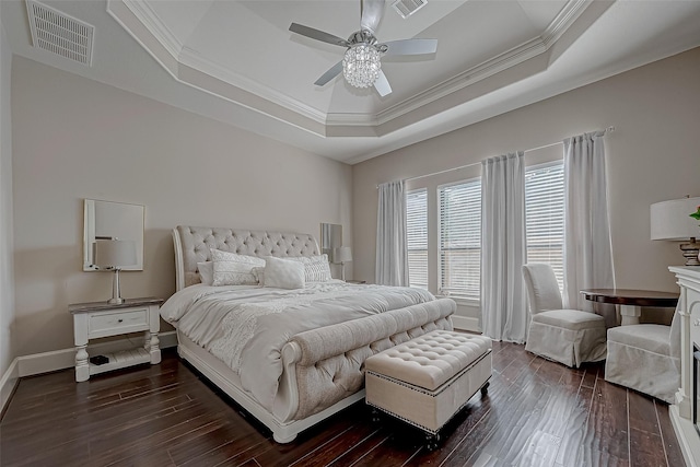 bedroom featuring ceiling fan, ornamental molding, a tray ceiling, and dark hardwood / wood-style flooring