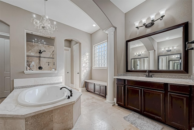 bathroom featuring vanity, decorative columns, and shower with separate bathtub