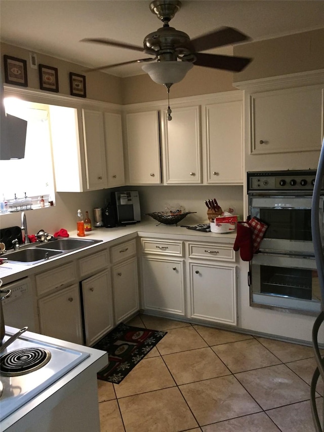 kitchen featuring white cabinetry, sink, light tile patterned floors, and double oven