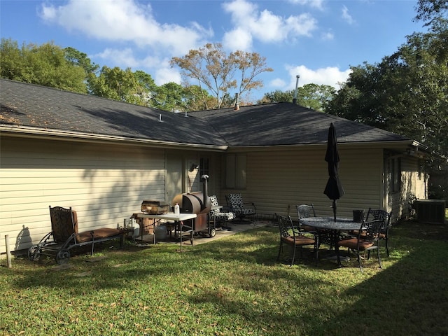 back of property with cooling unit, a yard, and a patio