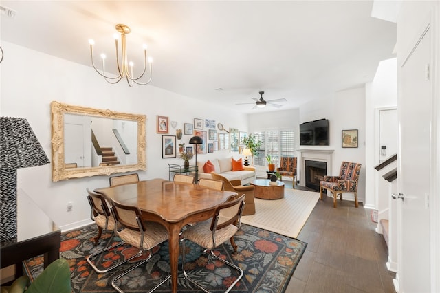 dining area featuring ceiling fan with notable chandelier