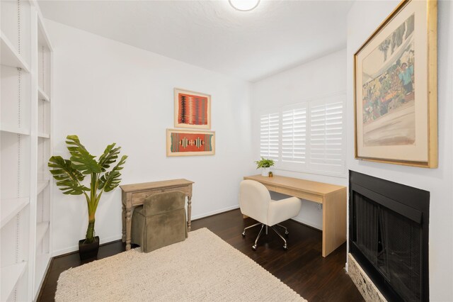 office featuring dark wood-type flooring and a fireplace