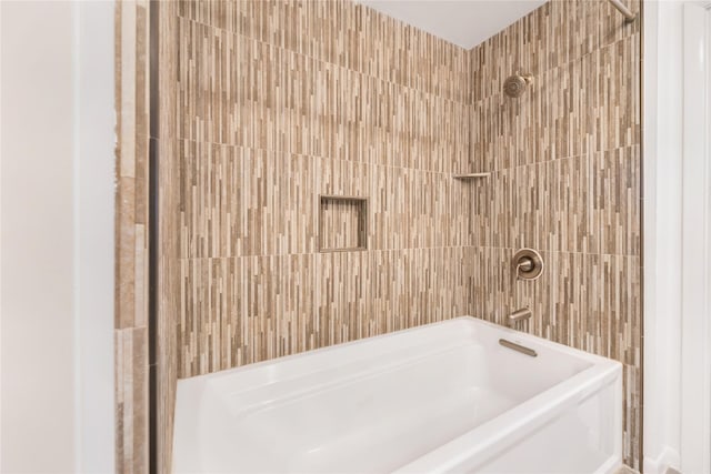 bathroom featuring tile walls and tiled shower / bath