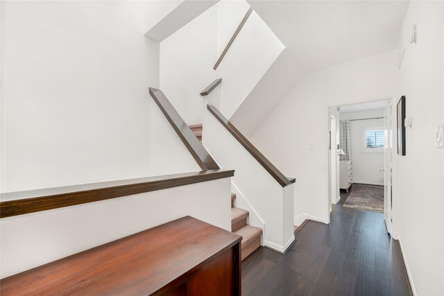 stairs with wood-type flooring and vaulted ceiling