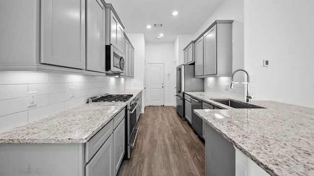 214 Fulton Station Dr, Houston, TX 77009 - kitchen featuring light stone counters, premium appliances, a sink, gray cabinets, and visible vents