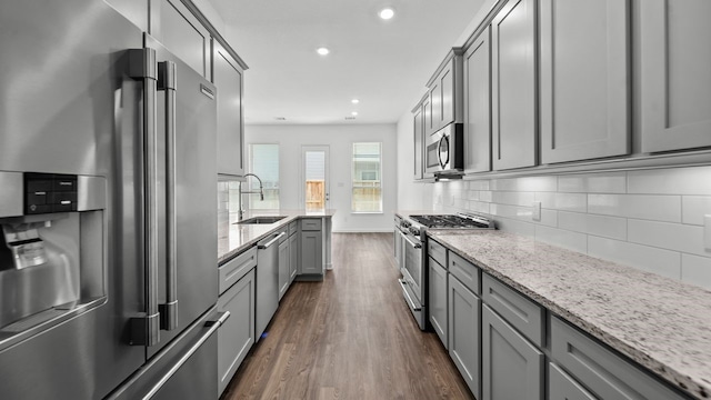 214 Fulton Station Dr, Houston, TX 77009 - kitchen with dark wood-style floors, a sink, backsplash, gray cabinets, and high quality appliances