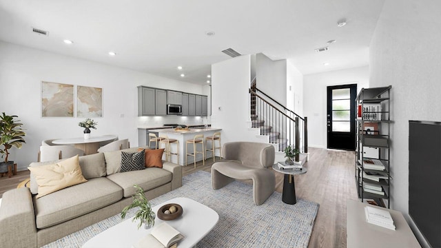 214 Fulton Station Dr, Houston, TX 77009 - living room featuring light wood-type flooring, visible vents, recessed lighting, and stairway