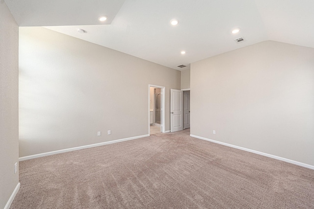 unfurnished room featuring lofted ceiling and light carpet