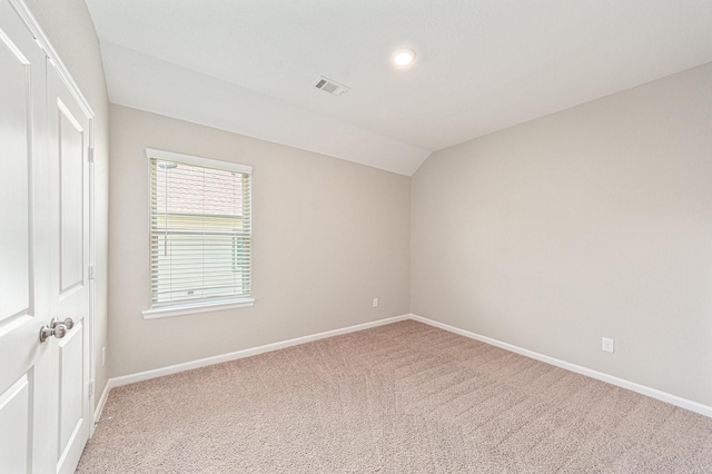 unfurnished room with lofted ceiling and carpet flooring