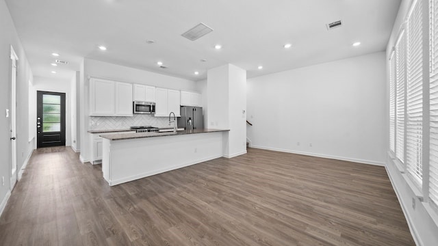 kitchen featuring sink, tasteful backsplash, dark hardwood / wood-style flooring, stainless steel appliances, and white cabinets