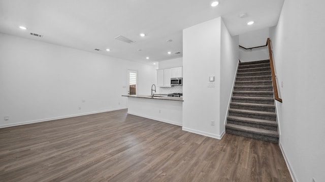 unfurnished living room with dark hardwood / wood-style flooring and sink