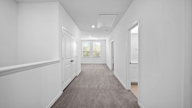 corridor featuring light colored carpet