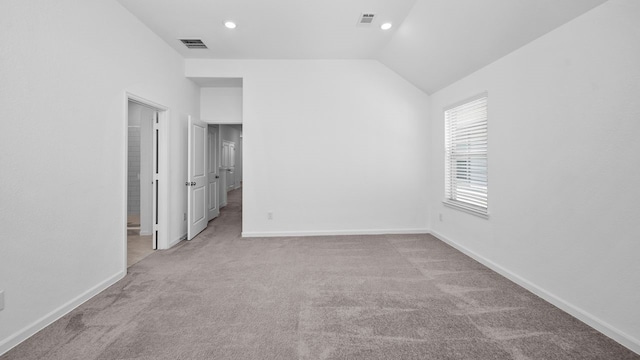 unfurnished bedroom featuring light colored carpet and vaulted ceiling