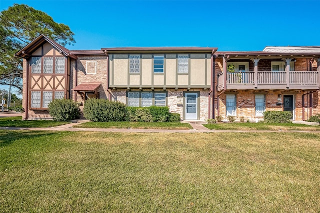 view of front of property with a balcony and a front yard