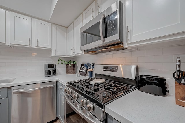 kitchen featuring backsplash, appliances with stainless steel finishes, and white cabinets