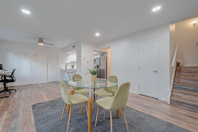 dining room with ceiling fan and light hardwood / wood-style floors