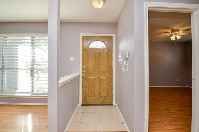 foyer with a textured ceiling, ceiling fan, and light tile patterned flooring