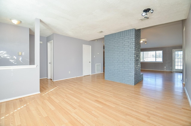 unfurnished room featuring a textured ceiling and light wood-type flooring