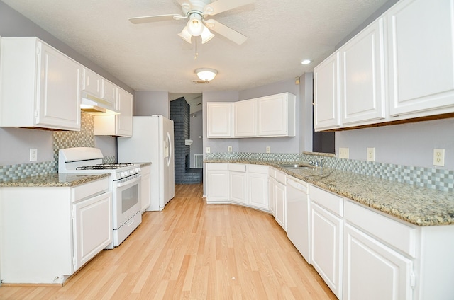 kitchen with white cabinetry, sink, white appliances, light stone countertops, and light wood-type flooring