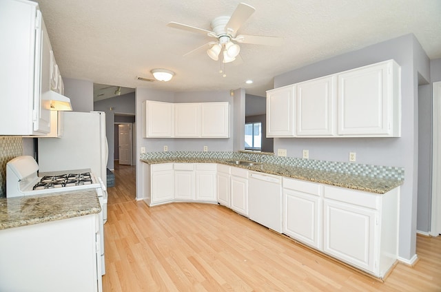 kitchen with light stone counters, white cabinets, and white appliances