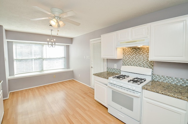 kitchen featuring stone counters, white cabinetry, backsplash, and white gas range oven