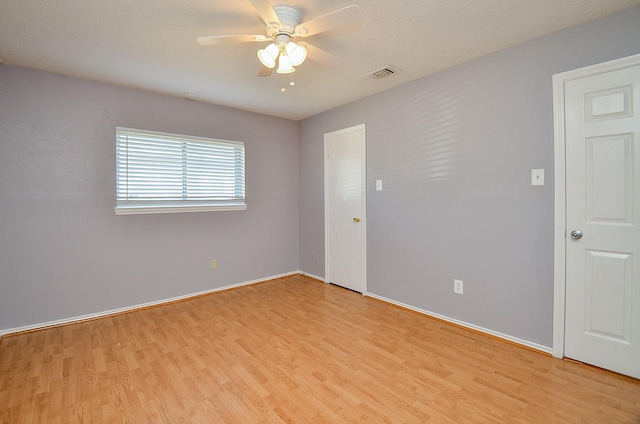 empty room featuring ceiling fan and light hardwood / wood-style flooring