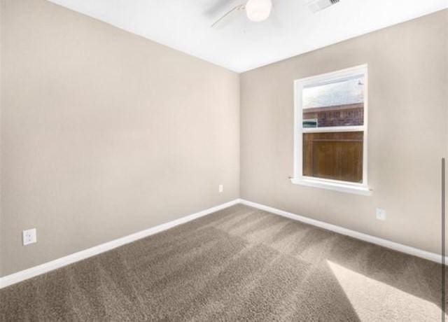 empty room with ceiling fan and carpet flooring