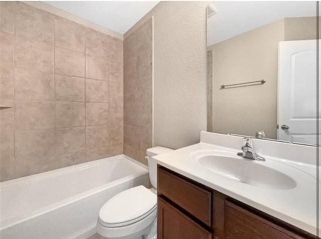 full bathroom featuring vanity, tiled shower / bath, and toilet