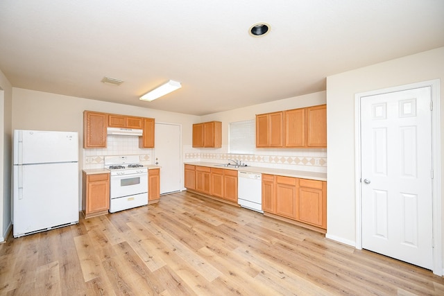 kitchen with tasteful backsplash, sink, white appliances, and light wood-type flooring