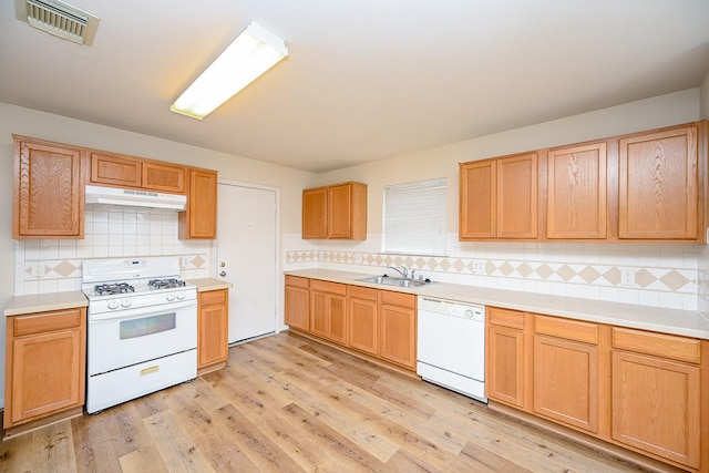 kitchen featuring sink, decorative backsplash, white appliances, and light wood-type flooring