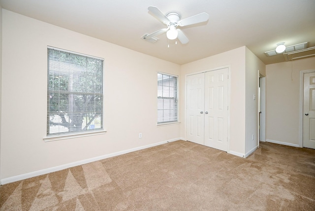 unfurnished bedroom featuring light carpet, ceiling fan, and a closet