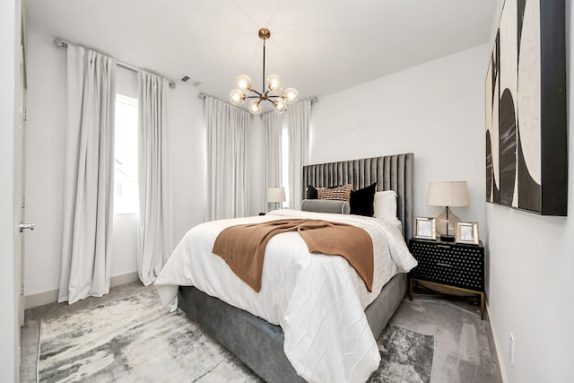 carpeted bedroom featuring visible vents, baseboards, and an inviting chandelier