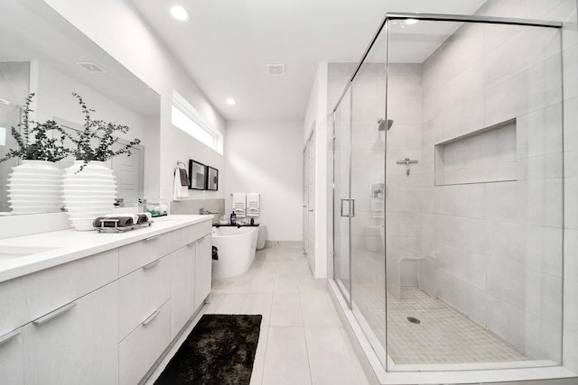 bathroom featuring a shower stall, double vanity, recessed lighting, a freestanding tub, and tile patterned floors