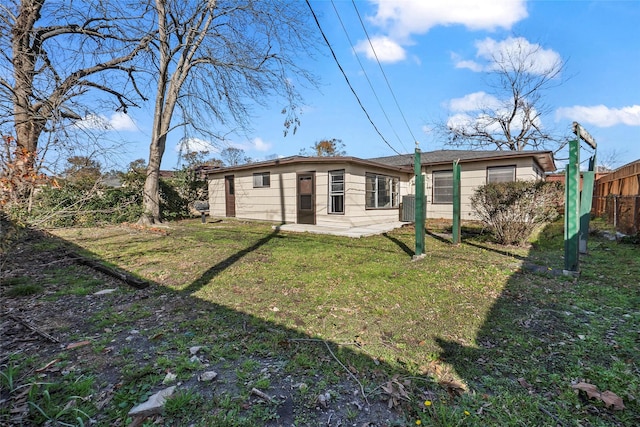 back of house featuring a patio area and a lawn