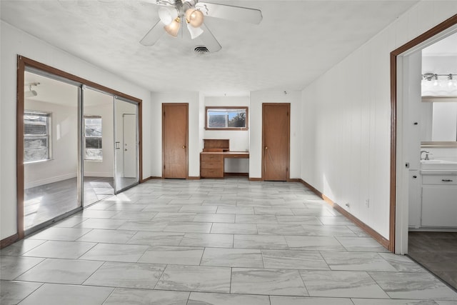 unfurnished living room with sink and ceiling fan