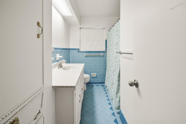 bathroom featuring tile patterned flooring, vanity, tile walls, and toilet