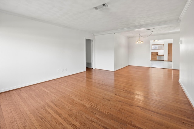 empty room with hardwood / wood-style flooring, ornamental molding, an inviting chandelier, and a textured ceiling