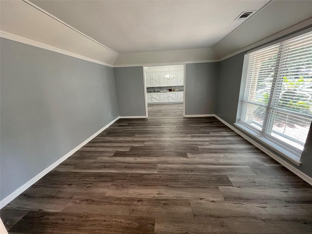 spare room featuring dark hardwood / wood-style flooring, ornamental molding, and lofted ceiling